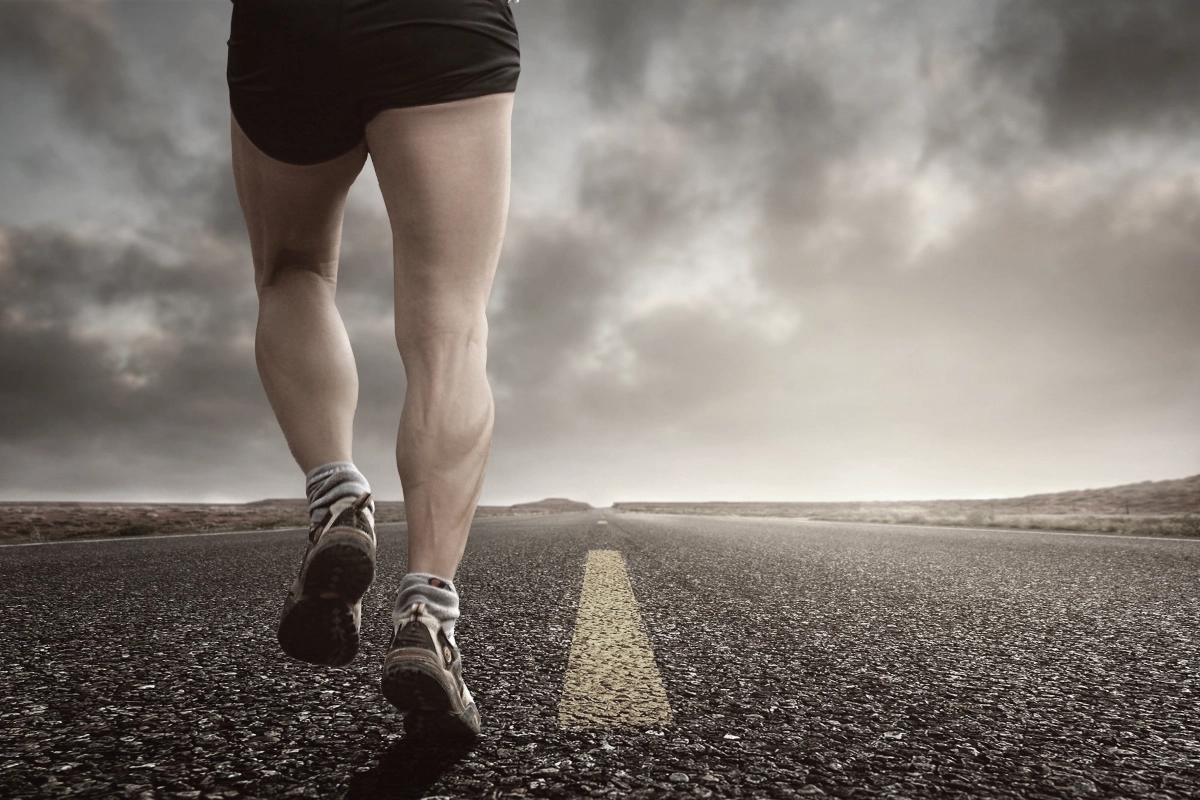 Jogger zeigt Wadenmuskeln – Lymphdrainage bei VitaSangius zur Regeneration und Entgiftung
