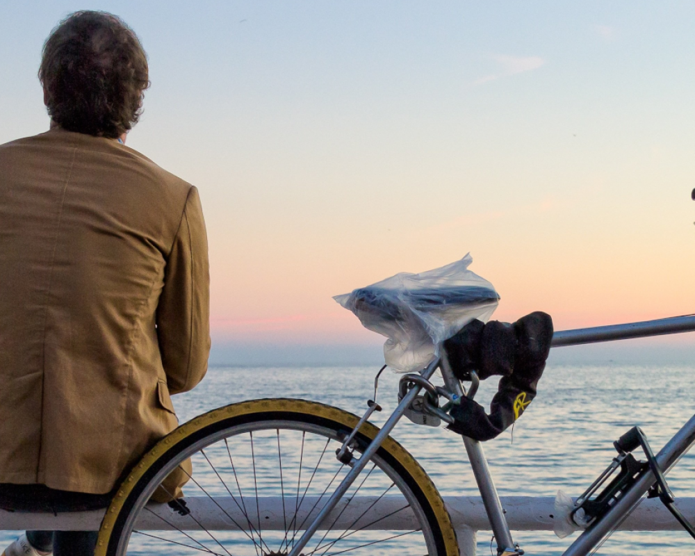 Paar sitzt entspannt am Meer und blickt in die Ferne – symbolische Darstellung von Ruhe, Regeneration und Ausgleich der humoralen Immunantwort.